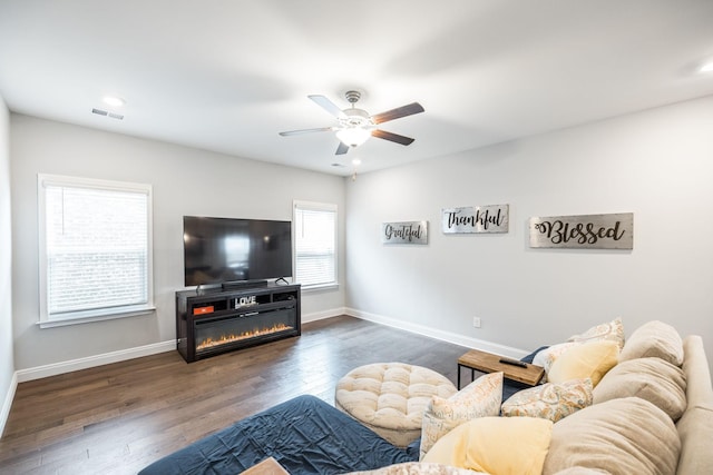 living room with ceiling fan and dark hardwood / wood-style flooring