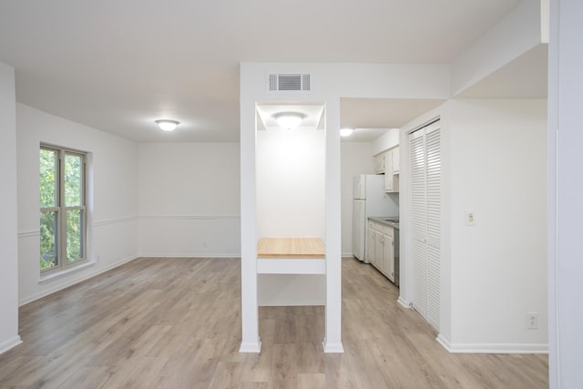 kitchen featuring white cabinetry, white fridge, and light hardwood / wood-style flooring