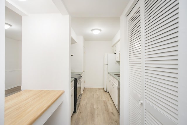 kitchen featuring range with electric stovetop, white cabinetry, white refrigerator, and light hardwood / wood-style floors