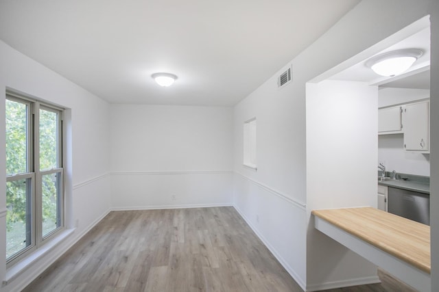 interior space featuring a healthy amount of sunlight, sink, and light hardwood / wood-style floors