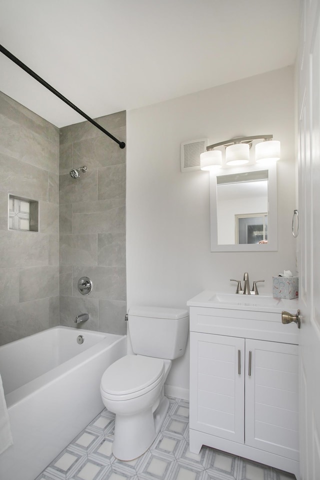 full bathroom with tiled shower / bath, vanity, and toilet