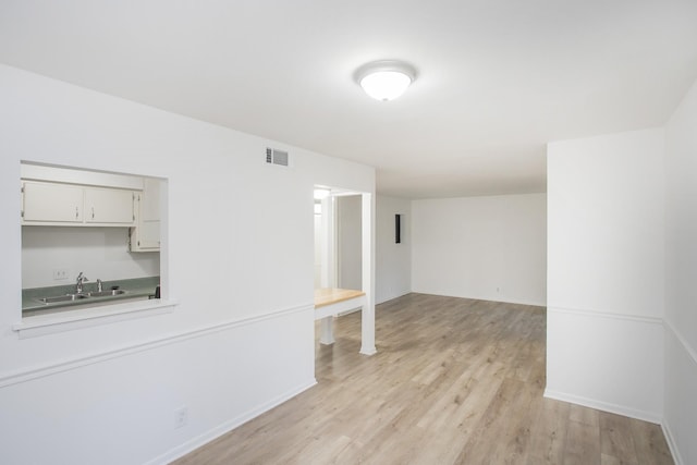 unfurnished living room featuring light hardwood / wood-style floors and sink