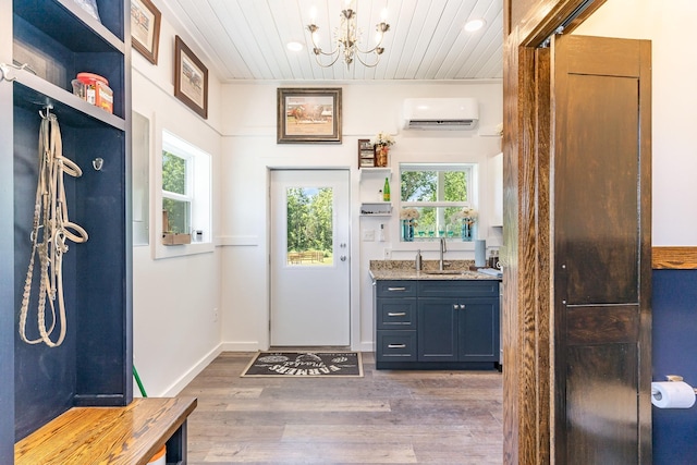 mudroom with sink, wood ceiling, dark wood-type flooring, an inviting chandelier, and a wall unit AC