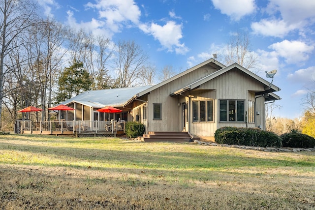 back of property with a wooden deck and a yard