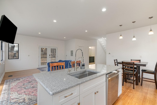 kitchen featuring sink, white cabinetry, an island with sink, stainless steel dishwasher, and french doors