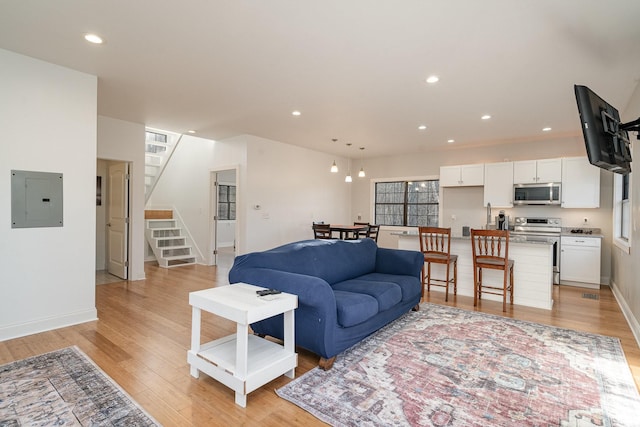 living room featuring electric panel and light wood-type flooring