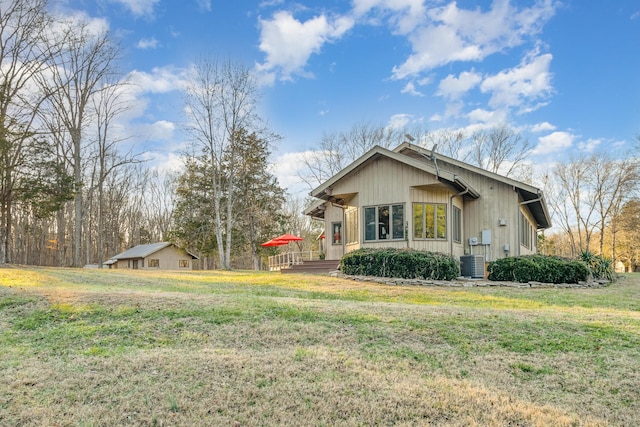 view of home's exterior with cooling unit and a lawn