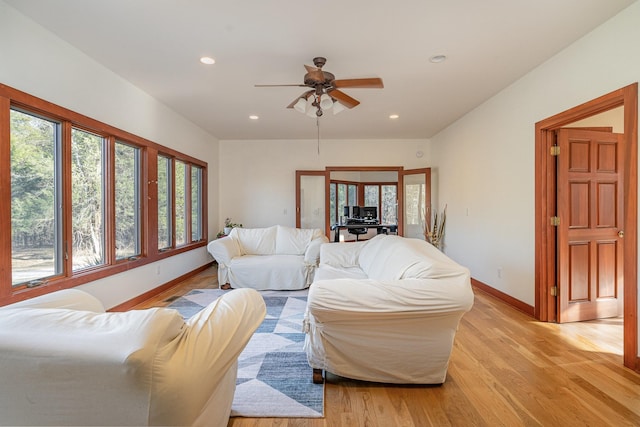 living room with ceiling fan and light wood-type flooring