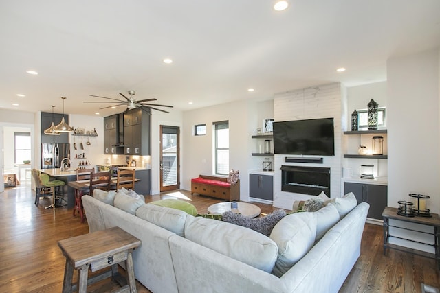 living room featuring a fireplace, dark hardwood / wood-style floors, and ceiling fan