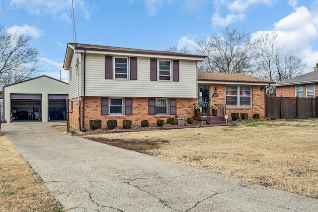 split level home with a garage, an outbuilding, central AC unit, and a front lawn