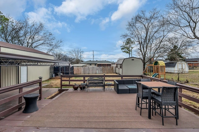 wooden deck with a gazebo, a storage shed, an outdoor hangout area, and a playground