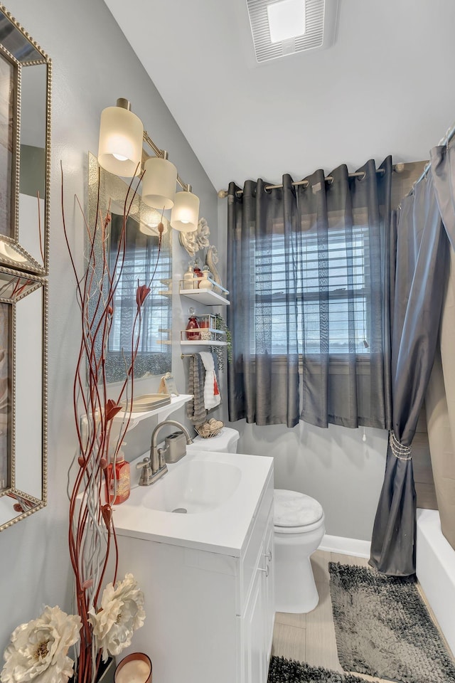 full bathroom with vanity, shower / bath combo, and toilet