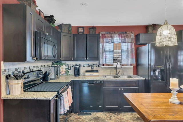 kitchen featuring sink, light stone counters, tasteful backsplash, black appliances, and decorative light fixtures