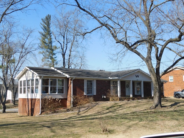 single story home featuring a sunroom and a front yard