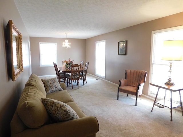 living room featuring light carpet, a notable chandelier, and a textured ceiling