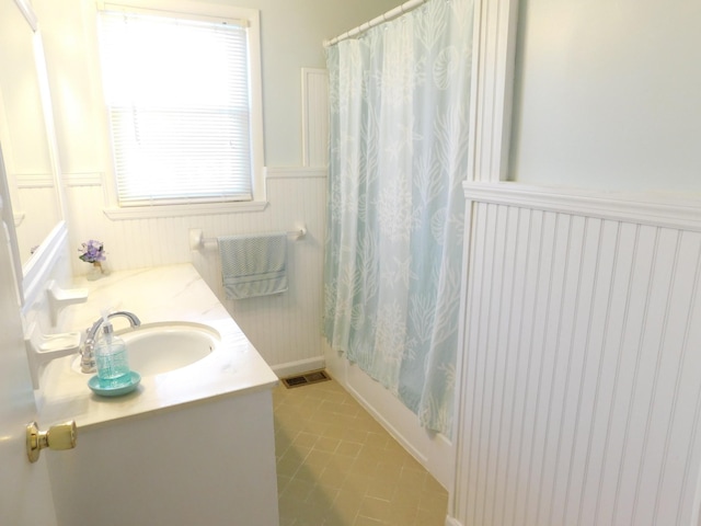 bathroom with tile patterned flooring, vanity, and shower / bathtub combination with curtain