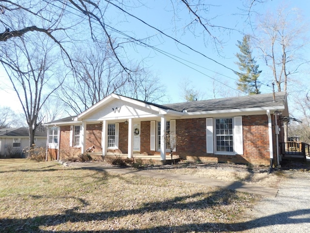 ranch-style home featuring a front lawn and a porch