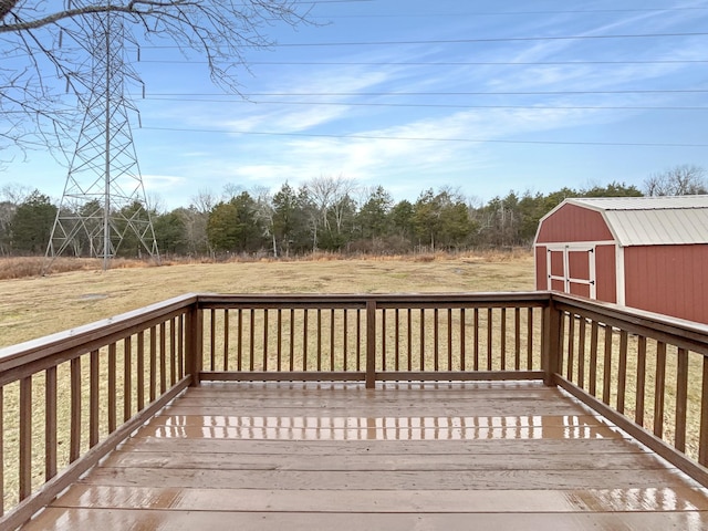 wooden deck with a lawn and a storage unit