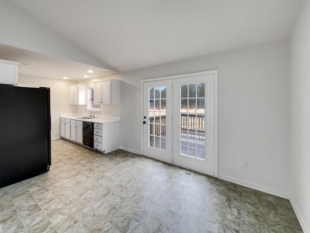 kitchen with lofted ceiling, sink, white cabinets, and black appliances