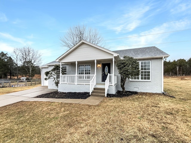 bungalow-style house featuring a garage, a front yard, and covered porch