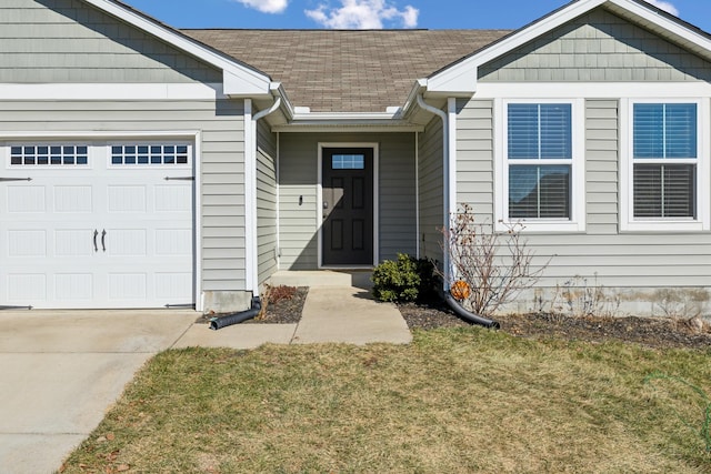 entrance to property featuring a yard and a garage