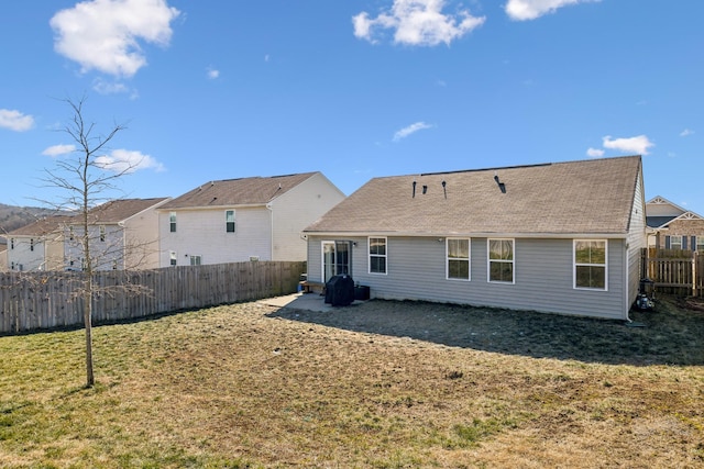 rear view of property featuring a patio and a lawn