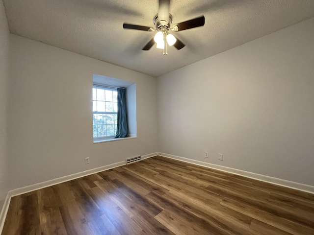 spare room featuring ceiling fan, dark hardwood / wood-style flooring, and a textured ceiling