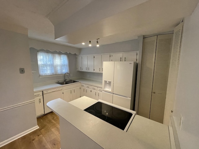 kitchen with sink, white appliances, wood-type flooring, and white cabinets