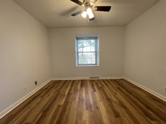 empty room featuring ceiling fan, dark hardwood / wood-style floors, and a textured ceiling