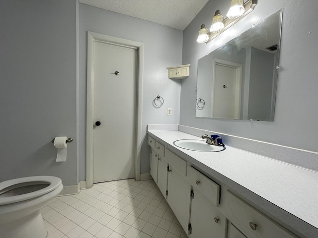 bathroom with vanity, tile patterned flooring, toilet, and a textured ceiling