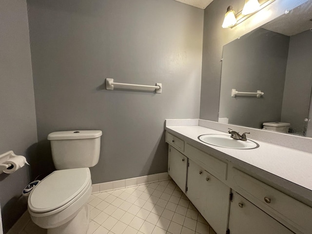 bathroom with vanity, tile patterned flooring, and toilet