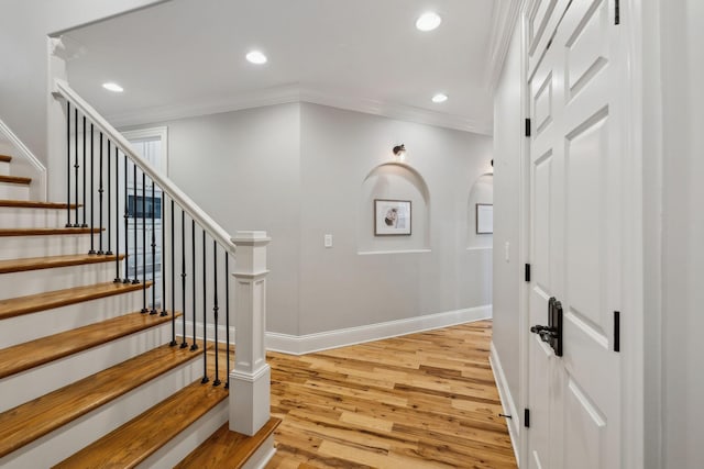 staircase featuring hardwood / wood-style floors and ornamental molding