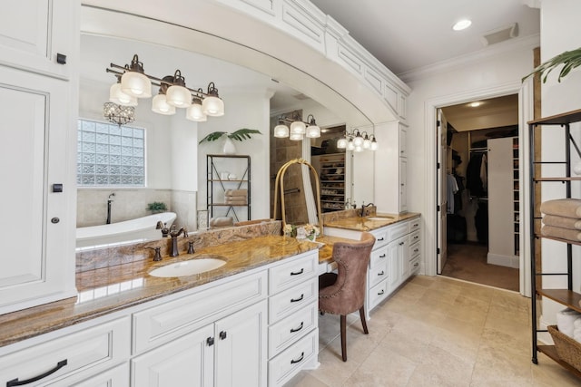 bathroom with vanity, ornamental molding, and a tub