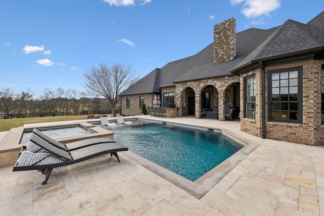 view of pool featuring a hot tub and a patio area