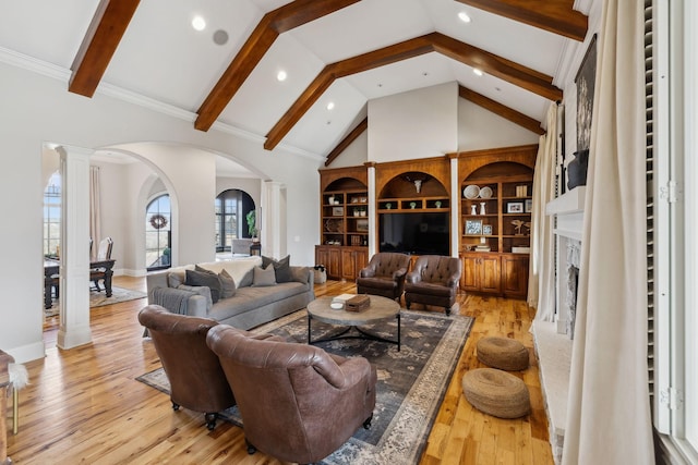 living room featuring ornate columns, high vaulted ceiling, a fireplace, beam ceiling, and light wood-type flooring