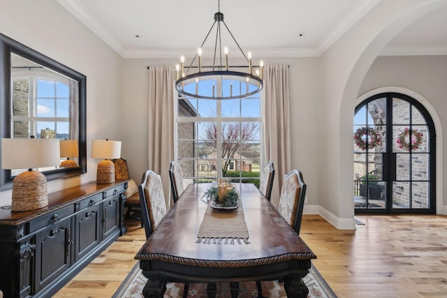 dining area with a wealth of natural light, a chandelier, and light hardwood / wood-style floors