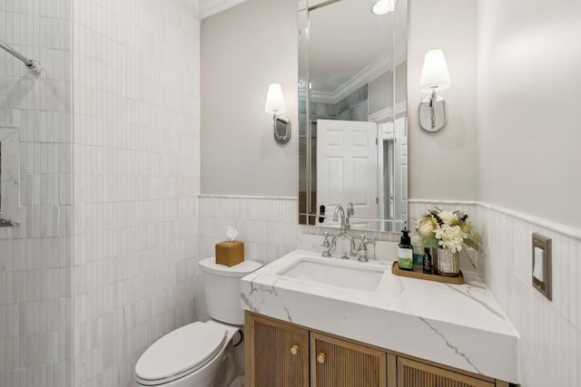 bathroom featuring vanity, crown molding, tile walls, and toilet