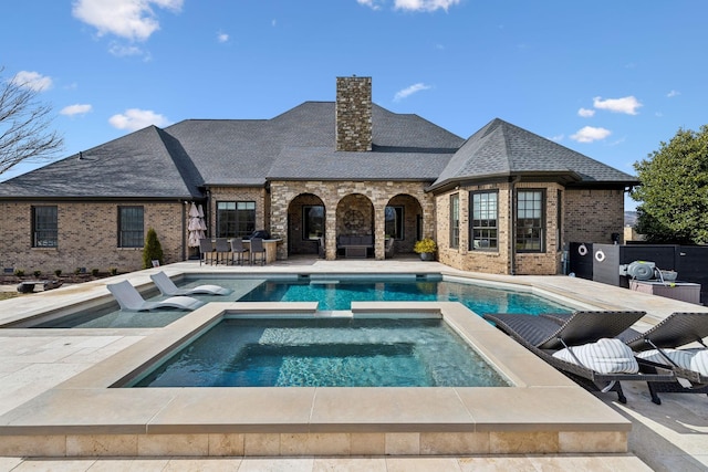 view of swimming pool featuring a patio area and an in ground hot tub