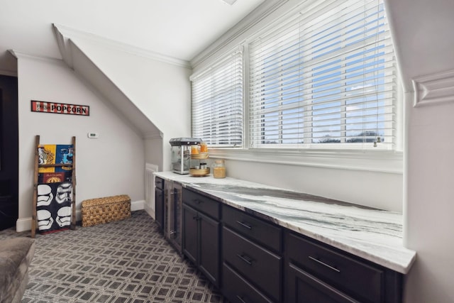 bar with crown molding and light stone counters