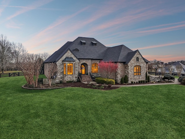 french country inspired facade with a yard