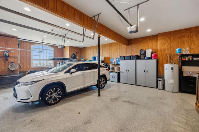 garage featuring a garage door opener, electric water heater, and wood walls