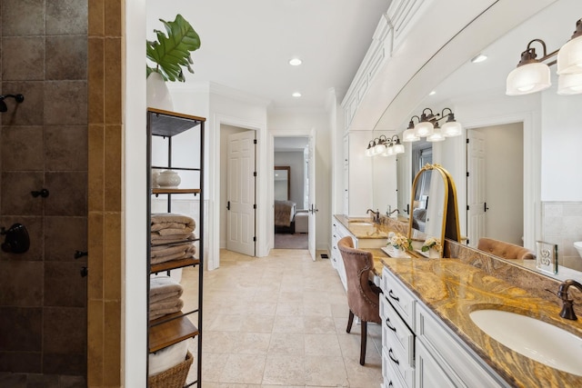 bathroom featuring crown molding, tiled shower, vanity, and tile patterned flooring