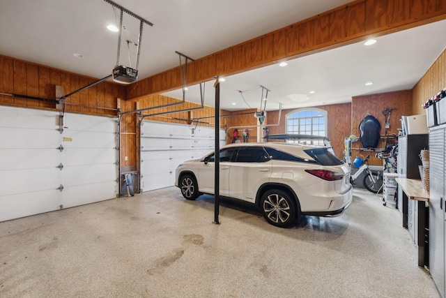 garage featuring a garage door opener and wood walls