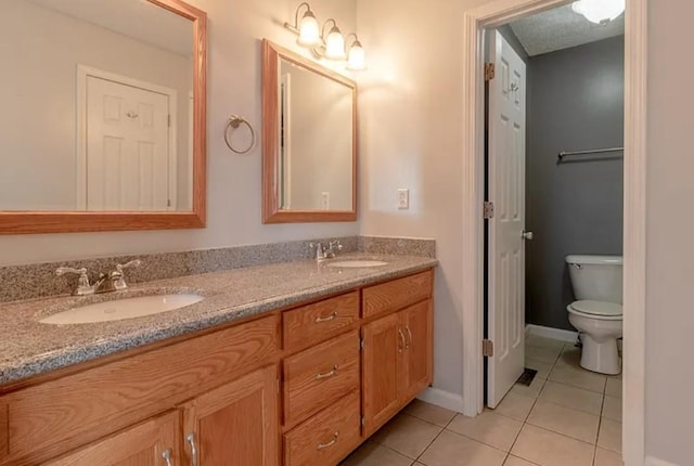 bathroom with tile patterned flooring, vanity, and toilet