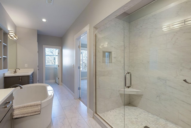 bathroom with vanity and shower with separate bathtub