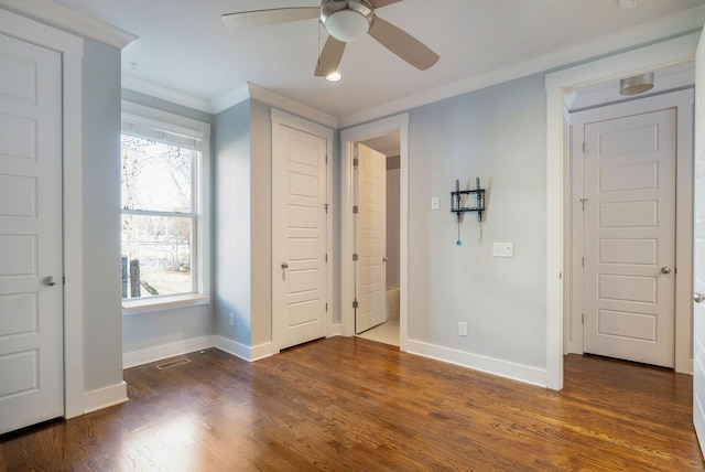 unfurnished bedroom with dark wood-type flooring, ornamental molding, and ceiling fan