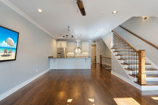 unfurnished living room with crown molding, dark hardwood / wood-style floors, and sink