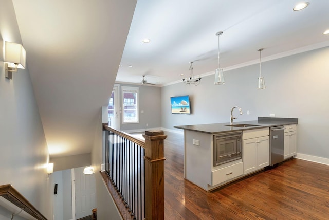 kitchen featuring built in microwave, white cabinetry, sink, hanging light fixtures, and kitchen peninsula