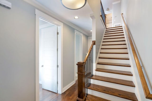 stairway featuring crown molding and wood-type flooring