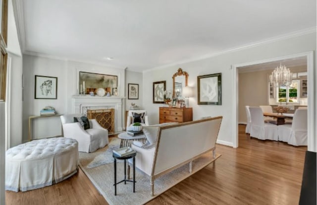 living room featuring ornamental molding, hardwood / wood-style floors, and an inviting chandelier